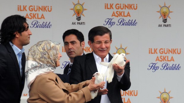 Turkish Prime Minister Ahmet Davutoglu and his wife Sare release doves at an AKP rally in Diyarbakir, a city with a large Kurdish population that in recent elections voted for the party in significant numbers.