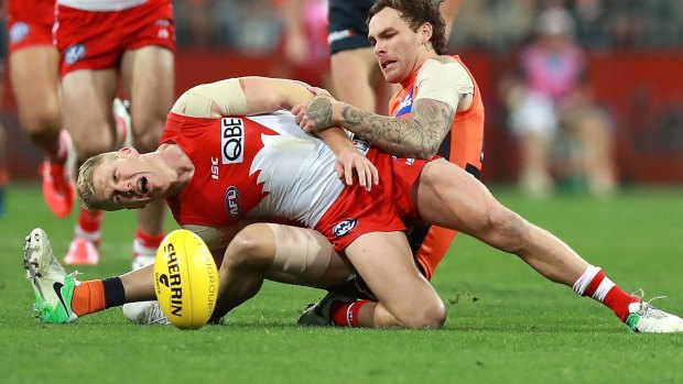 Rugged contest: Dan Hannebery of the Swans is tackled by Nathan Wilson.
