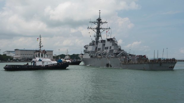 Tugboats from Singapore assist USS John S. McCain as it steers towards Changi Naval Base.