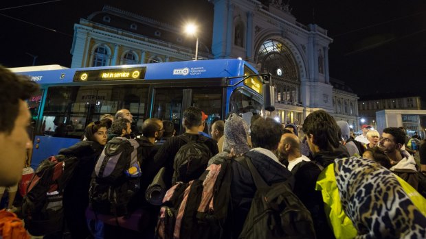 Migrants board buses outside Keleti railway station in central Budapest on Friday night.
