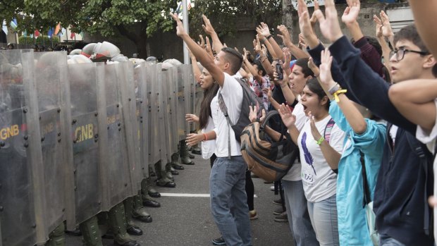 Anti-government protesters are blocked by the national guard in Caracas on Friday.