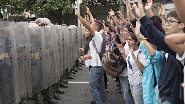 Anti-government protesters are blocked by the national guard in Caracas on Friday.