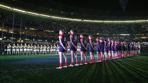 Players stand for the Last Post for the Anzac Day-eve clash in 2015. 