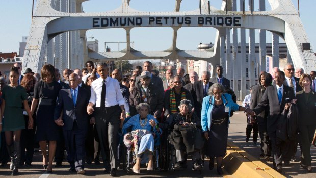 President Barack Obama, fourth from left, his family and dignitaries sing We Shall Overcome to mark 50th anniversary of Selma Civil Rights March. 