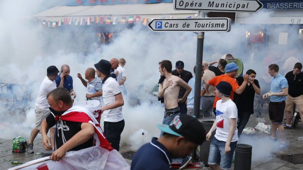 England supporters run from French police firing tear gas in downtown Marseille, France.