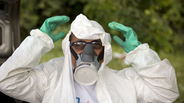 A municipal health worker prepares to spray insecticide on Monday in a scrapyard in Joao Pessoa, Brazil, to combat the mosquitoes that transmit the Zika virus.
