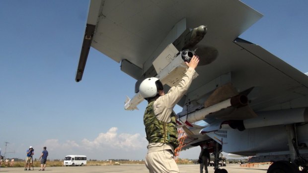 A Russian pilot fixes an air-to-air missile on his Su-30 jet fighter before take-off at Hmeimim airbase in Syria on Monday.