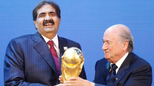Bidding process: Sheikh Hamad bin Khalifa Al-Thani, emir of Qatar (left), is presented with the World Cup trophy by former FIFA president Sepp Blatter after being awarded hosting rights for the 2022 tournament.