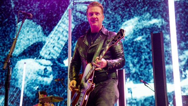 Josh Homme of Queens of the Stone Age was shown kicking a female photographer at a concert.