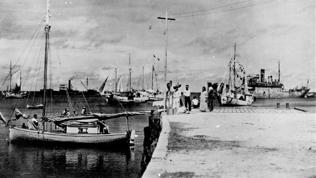 This undated photo discovered in the U.S. National Archives by Les Kinney shows people on a dock in Jaluit Atoll, Marshall Islands. A new documentary film proposes that this image shows aviator Amelia Earhart, seated third from right, gazing at what may be her crippled aircraft loaded on a barge. 