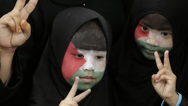 Filipino Muslims, with their faces painted with the colors of the Palestinian flag, flash peace signs during a rally outside the Israeli Embassy in Manila on Tuesday.