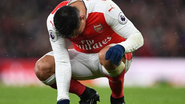 Feeling the strain: Alexis Sanchez goes down on his haunches against Crystal Palace on New Year's Day.