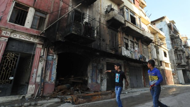 Lebanese boys walk past a burnt-out building on a street in Tripoli's Bab al-Tabbaneh Sunni neighbourhood after three days of fierce fighting between Lebanese forces and armed Islamists.