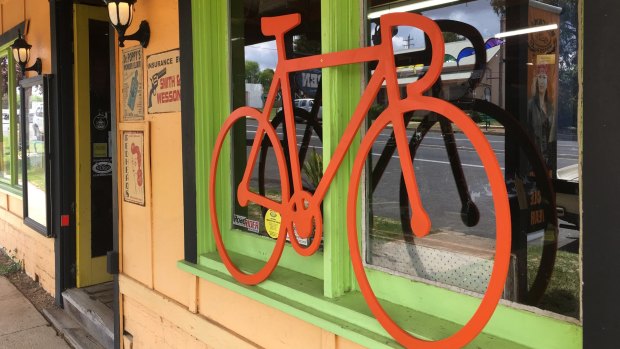 One of the many orange bike cut-outs appearing in shop windows around the region in support of the Monaro Rail Trail.
