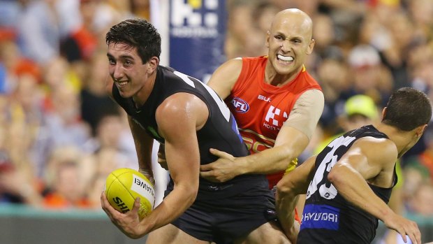 Jacob Weitering of the Blues is tackled by Gary Ablett of the Suns.