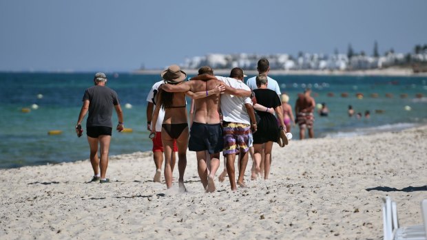 People lock arms after viewing the deadly scene at the beach.