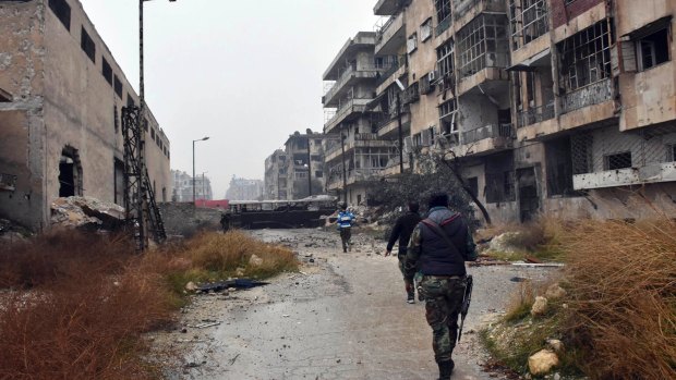 Syrian troops march through the streets of east Aleppo.