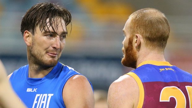 Charlie Dixon of the Suns and Daniel Merrett of the Lions exchange words during the Q-Clash at The Gabba.
