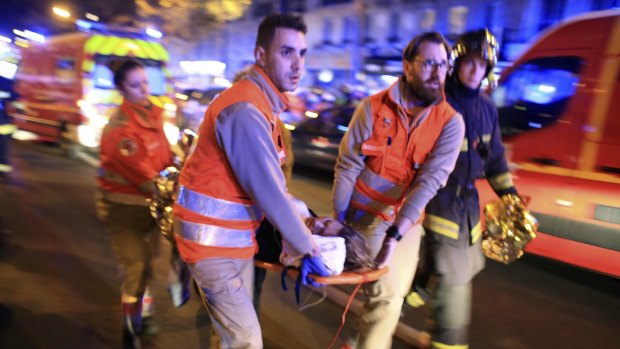 A woman is evacuated from the Bataclan theatre in Paris on Friday night after a terrorist attack.