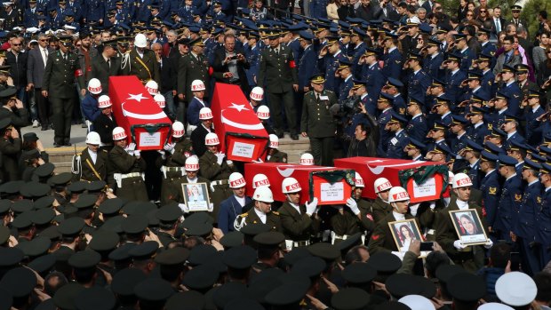 Soldiers carry the coffins of eight of the 28 victims of Wednesday's bomb attack in Ankara.
