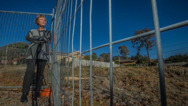 Felicity Prideaux, a former Mr Fluffy homeowner who participated in ANU's study into the health impacts of loose-fill asbestos on former residents- in front of the location of her former home in Hackett, now just a cleared block,