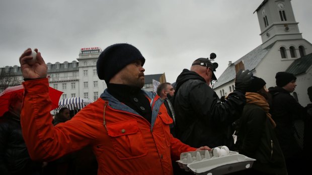 A protester throws an egg at the parliament building as hundreds demonstrate in Reykjavik, Iceland.