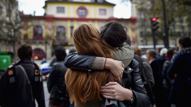 Two girls embrace opposite the main entrance of Bataclan concert hall as French police lift the cordon following Fridays terrorist attacks. 