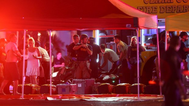Medics treat the wounded as Las Vegas police respond to the shooting on the Las Vegas Strip on Sunday.