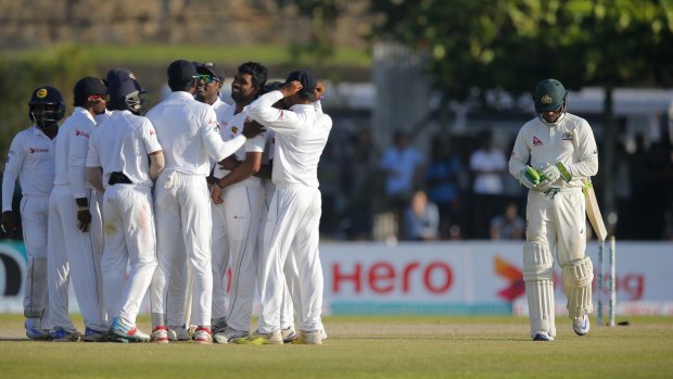 Sri Lankan cricketers celebrate the wicket of Australia's Usman Khawaja on Day two of the second Test.