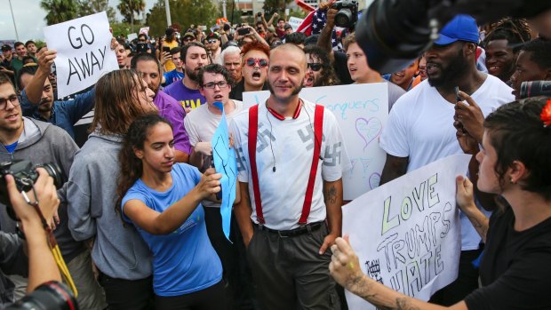 Protesters confront a man wearing a shirt with swastikas outside a University of Florida auditorium where white nationalist Richard Spencer spoke. 