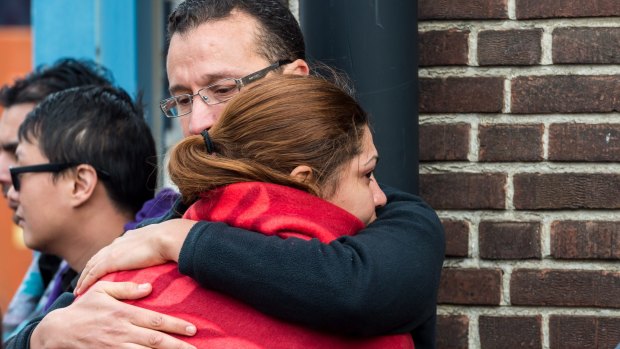 People comfort each other after being evacuated from Brussels airport, after the explosions.