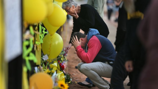 Stephanie Scott's mother Merrilyn and fiance Aaron Leeson-Woolley at the floral memorial on the gates of the Leeton High School last year.