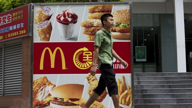 A pedestrian walks past an advertisement for McDonald's in the Futian district of Shenzhen, China, where sales have been hit hard after a McDonald's supplier was accused of repackaging old meat. 