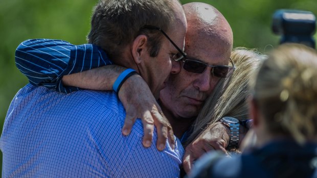 Tara Costigan's family members embrace after her killer was sentenced to a minimum of 26 years in jail. 