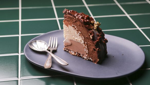 A slice of gelato cake with a backdrop of Piccolina's signature green tiles.