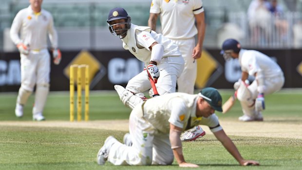 Among the runs: David Warner hits the deck as Cheteshwar Pujara (centre) and Ajinkya Rahane score  off Mitchell Johnson. 