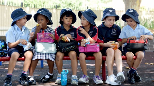 Students sit at St Oliver's Primary School in Harris Park where there is a compulsory hat policy.
