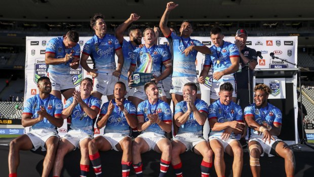 Top of the world: The Roosters squad celebrate after their Nines championship.