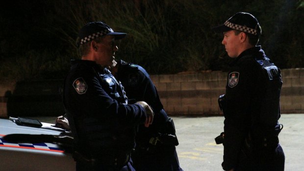 Acting Inspector Andrew Dupere, left, speaking to other officers about the search for a man missing in the Brisbane River on Saturday, July 11, 2015.