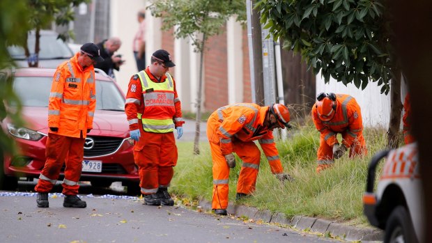 Emergency service workers scour Woonah Street, Chadstone, for clues after the double shooting.