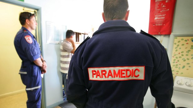A man has been charged with punching a paramedic in the back of an ambulance.