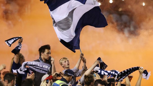 Melbourne Victory fans celebrate a goal on Saturday night.