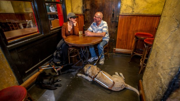 Guide dog handler Jo Weir and fiancee Justin Simpson with their guide dogs Wiley (black) and Yarrin (gold) enjoying King O'Malley's Pub in Civic. 