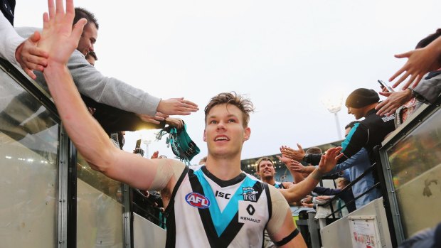 Port Adelaide's Logan Austin celebrates the win over Collingwood with fans.