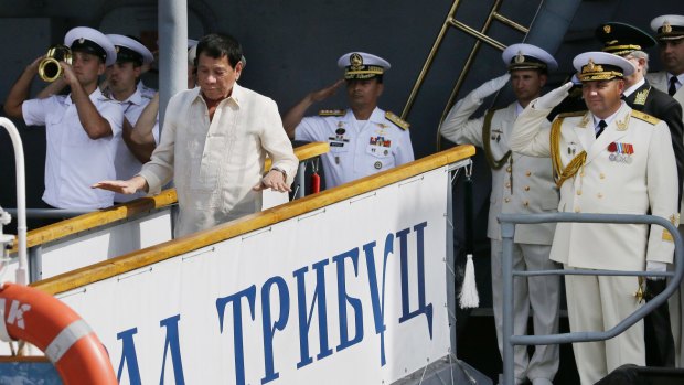 Russian Navy and a Philippine officer salute as Philippine President Rodrigo Duterte alights from the Russian anti-submarine Navy vessel Admiral Tributs in Manila, Philippines.