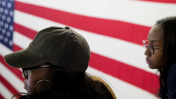 Young women listen as Democratic presidential candidate Hillary Clinton speaks.