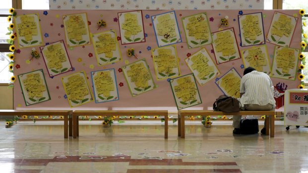 A tourist sits near messages of support for survivors, at Fukushima station in Japan last month.