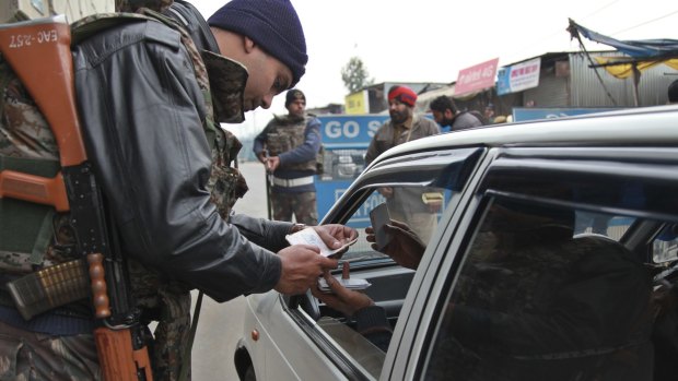 Indian security personnel check people entering an air base in Pathankot.