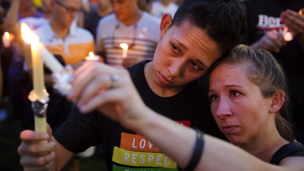 Jennifer, right, and Mary Ware light candles during a vigil downtown for the victims of a mass shooting at the Pulse nightclub.