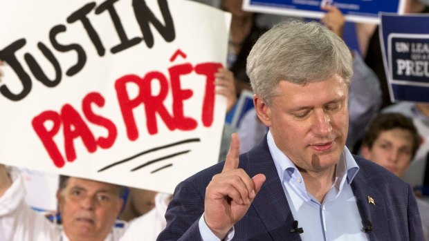 Canadian Prime Minister Stephen Harper speaks to supporters during a rally in Montreal. The sign in the background reads: "Justin (Trudeau) not ready". 
